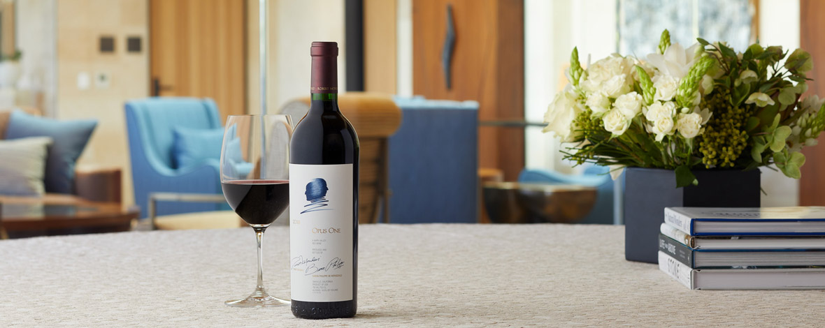 A bottle of Opus One 2018 next to a wine glass in the Partners' Room