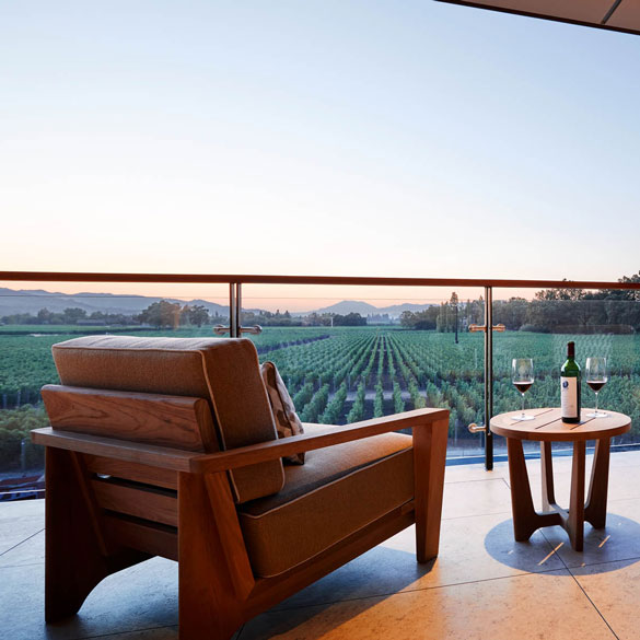The Veranda of the new Partners' Room overlooking green vineyards, with a bottle of Opus One and wine glasses
