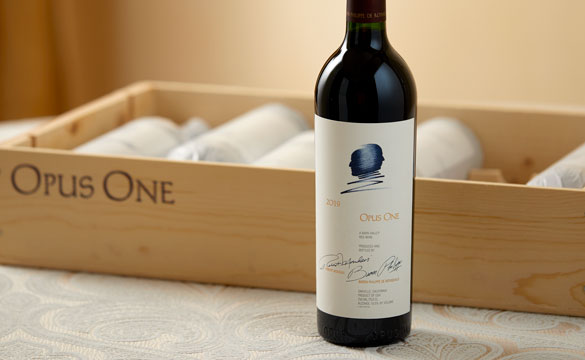 A bottle of Opus One 2019 with an original wooden case in the background