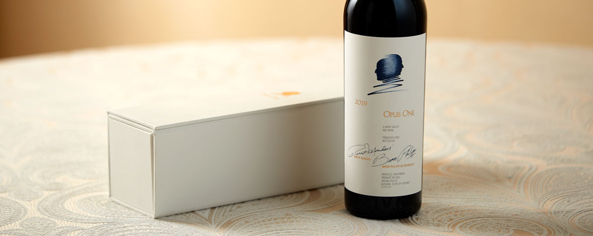 A bottle of Opus One 2019 next to a white gift box
