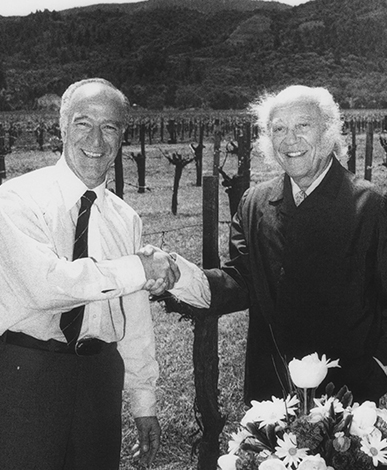 Robert Mondavi and Baron Philippe de Rothschild shaking hands.