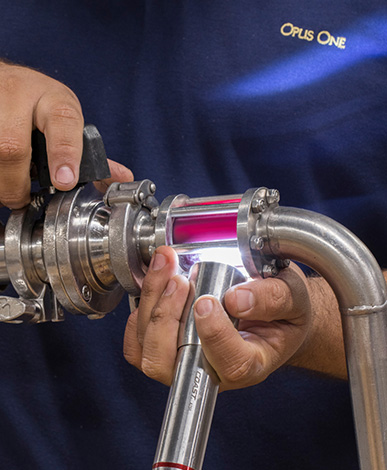 Observing the wine as it flows through the sight glass during racking